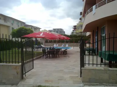 a patio with tables and chairs with umbrellas at Femili Hotel Diveda in Sveti Vlas
