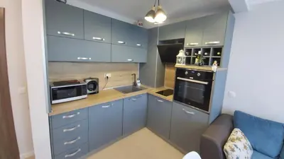 a small kitchen with blue cabinets and a microwave at Ravda on the Beach in Ravda