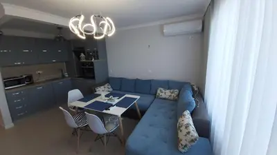 a living room with a blue couch and a table at Ravda on the Beach in Ravda