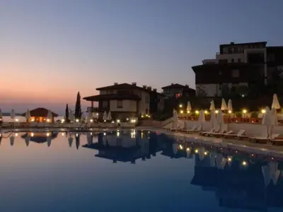 a pool with chairs and lights in a resort at Santa Marina resort Sozopol - penthouse with amazing sea view in Sozopol