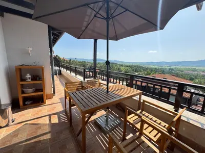 a wooden table with an umbrella on a balcony at Santa Marina resort Sozopol - penthouse with amazing sea view in Sozopol