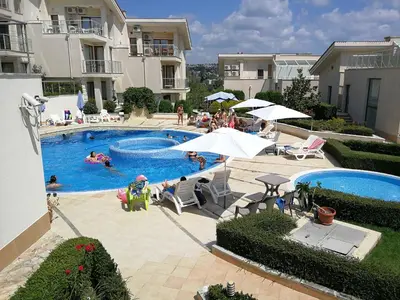 an outdoor swimming pool with people in a resort at Wonderful family villa with sea view in Byala