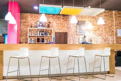 a bar in a restaurant with white stools at Admiral Plaza Hotel in Sunny Beach