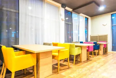 a row of tables and chairs in a room with windows at Admiral Plaza Hotel in Sunny Beach