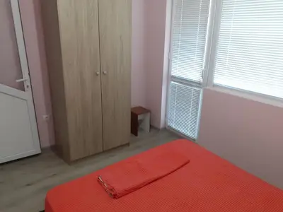 a bedroom with a bed with a red blanket on it at Varna beach in Varna City