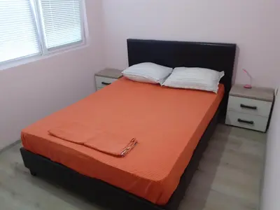 a bed with an orange blanket and two pillows at Varna beach in Varna City