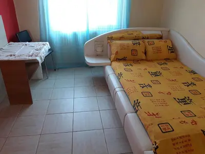 a room with a bed and a table and a window at гостевой дом у Снежаны in Provadiya
