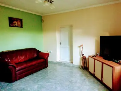 a living room with a red couch and a television at гостевой дом у Снежаны in Provadiya