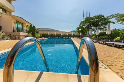 a swimming pool with two metal railings next to a building at Hotel Julia in Sveti Vlas