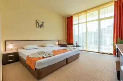 a bedroom with a large bed and a large window at Hotel Julia in Sveti Vlas
