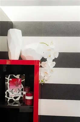 a red and white shelf with a vase and flowers at Luxury Apartments Burgas in Burgas City