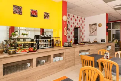 a restaurant with yellow walls and a table and chairs at Iris Beach Hotel in Sveti Vlas