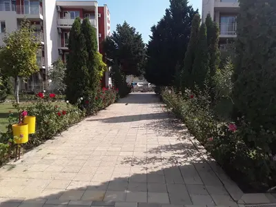 a sidewalk in a city with flowers and trees at FORT NOKS NESSEBAR B2-203 Private Studio Sunny Beach in Sunny Beach
