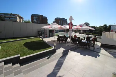 a patio with tables and chairs and umbrellas at PARADISO 'В' 310 Private Room Nessebar in Nesebar