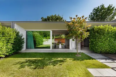 a home with a garden with a tree in the yard at Vaya Beach Resort in Emona