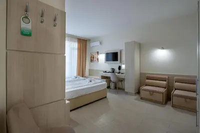 a hotel room with a bed and a table and chairs at Perla Apartments First Line in Nesebar