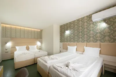 a hotel room with two beds with white sheets at Perla Apartments First Line in Nesebar