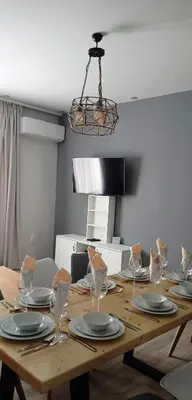 a wooden table with plates and wine glasses on it at Apartment SEA HOLIDAYS in Burgas City