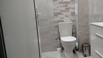 a bathroom with a toilet and a glass shower at Apartment SEA HOLIDAYS in Burgas City
