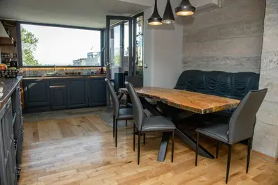 a kitchen and dining room with a wooden table and chairs at ART LUXURY Apartment in Burgas City