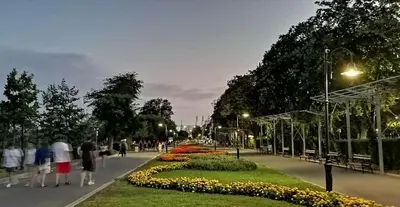 a group of people walking in a park at night at ART LUXURY Apartment in Burgas City