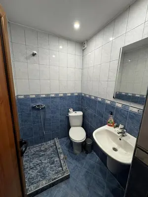 a blue tiled bathroom with a toilet and a sink at Bar & Guests room ELA in Dolen Bliznak
