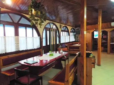 a dining room with a table and some windows at Bar & Guests room ELA in Dolen Bliznak