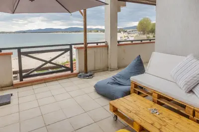 a balcony with a couch and an umbrella and a bench at Lovely 3BD flat with PARKING and SEA VIEW by Flаt Manаger in Chernomorets