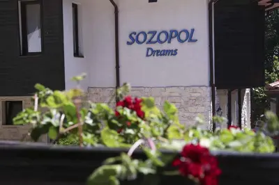 a sign on the side of a building with red flowers at Sozopol Dreams apartman 35 in Sozopol