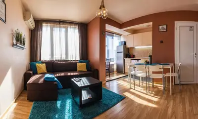 a living room with a couch and a table and a kitchen at LunApart in Varna City