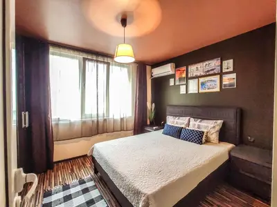 a bedroom with a bed and a large window at LunApart in Varna City