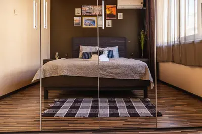 a bedroom with a bed with a black and white rug at LunApart in Varna City