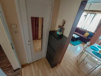 a living room with a dresser and a room with a couch at LunApart in Varna City