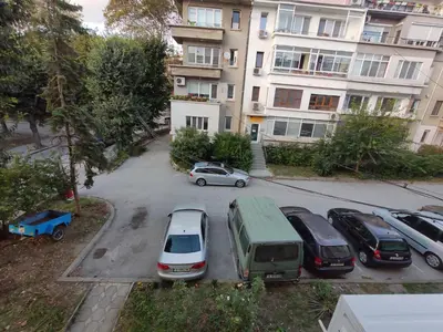 a parking lot with cars parked in front of a building at LunApart in Varna City