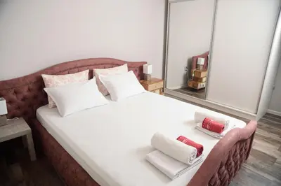 a bedroom with a white bed with two pillows on it at Apartment MARTINI in Burgas City