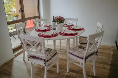 a white dining room table with red plates and chairs at Bella's Sea apartment-Beach, Sea garden ,Old Town, Free Parking, Free EVcharging Station in Varna City