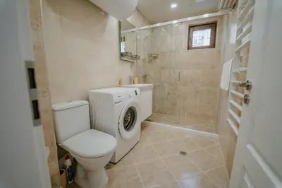 a bathroom with a toilet and a washing machine at Bella's Sea apartment-Beach, Sea garden ,Old Town, Free Parking, Free EVcharging Station in Varna City
