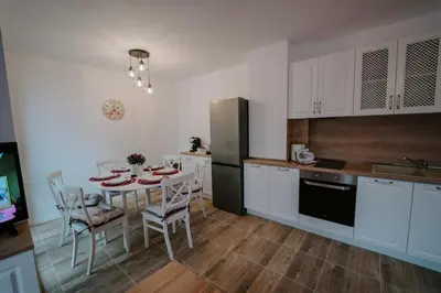 a kitchen with a table with chairs and a refrigerator at Bella's Sea apartment-Beach, Sea garden ,Old Town, Free Parking, Free EVcharging Station in Varna City