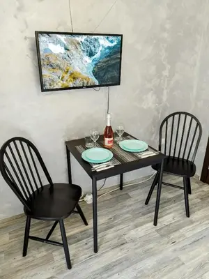 a dining room table with two chairs and a painting at Aпартамент 5 in Varna City