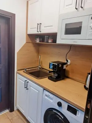 a kitchen with a sink and a coffee maker on a counter at Aпартамент 5 in Varna City