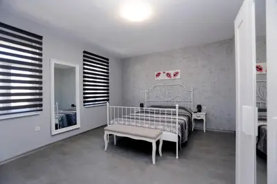 a bedroom with a bed and a chair and a mirror at Lux Apartment 