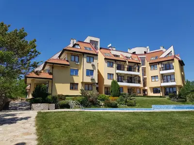 a large yellow building with a red roof at CarolMike Oasis Beach Apartment Kamchia Reserve in Kamchia