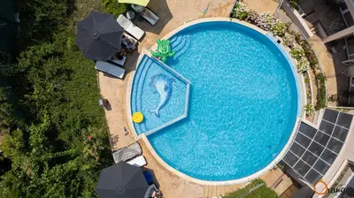 an overhead view of a large swimming pool with umbrellas at Villa Orange in Sozopol