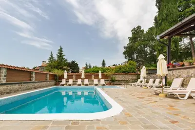 a swimming pool with chaise lounge chairs and an umbrella at VILLA SOL in Sunny Beach