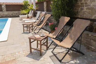 a row of chairs and a table next to a pool at VILLA SOL in Sunny Beach