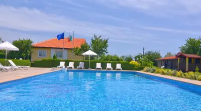 a swimming pool with chairs and a house at BulgariaVilla - Villa Amber in Bryastovets