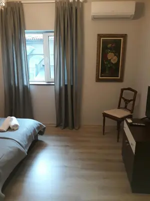 a bedroom with a bed and a chair and a window at Flat in Varna, central location, close to beach in Varna City