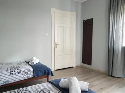 a bedroom with two beds and a white door at Flat in Varna, central location, close to beach in Varna City
