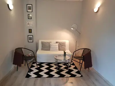a room with a bed and two chairs and a table at Flat in Varna, central location, close to beach in Varna City