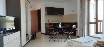 a room with a kitchen and a table with chairs at Pearl Apartments Sozopol in Sozopol